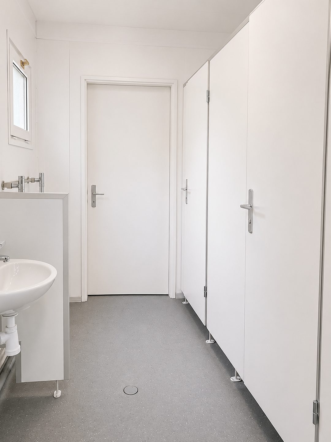 Sanitärbereich mit Waschtisch und Kabinentüren