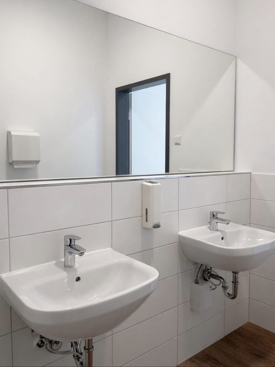 Gereinigter Waschtischbereich mit zwei Waschbecken und Spiegel
