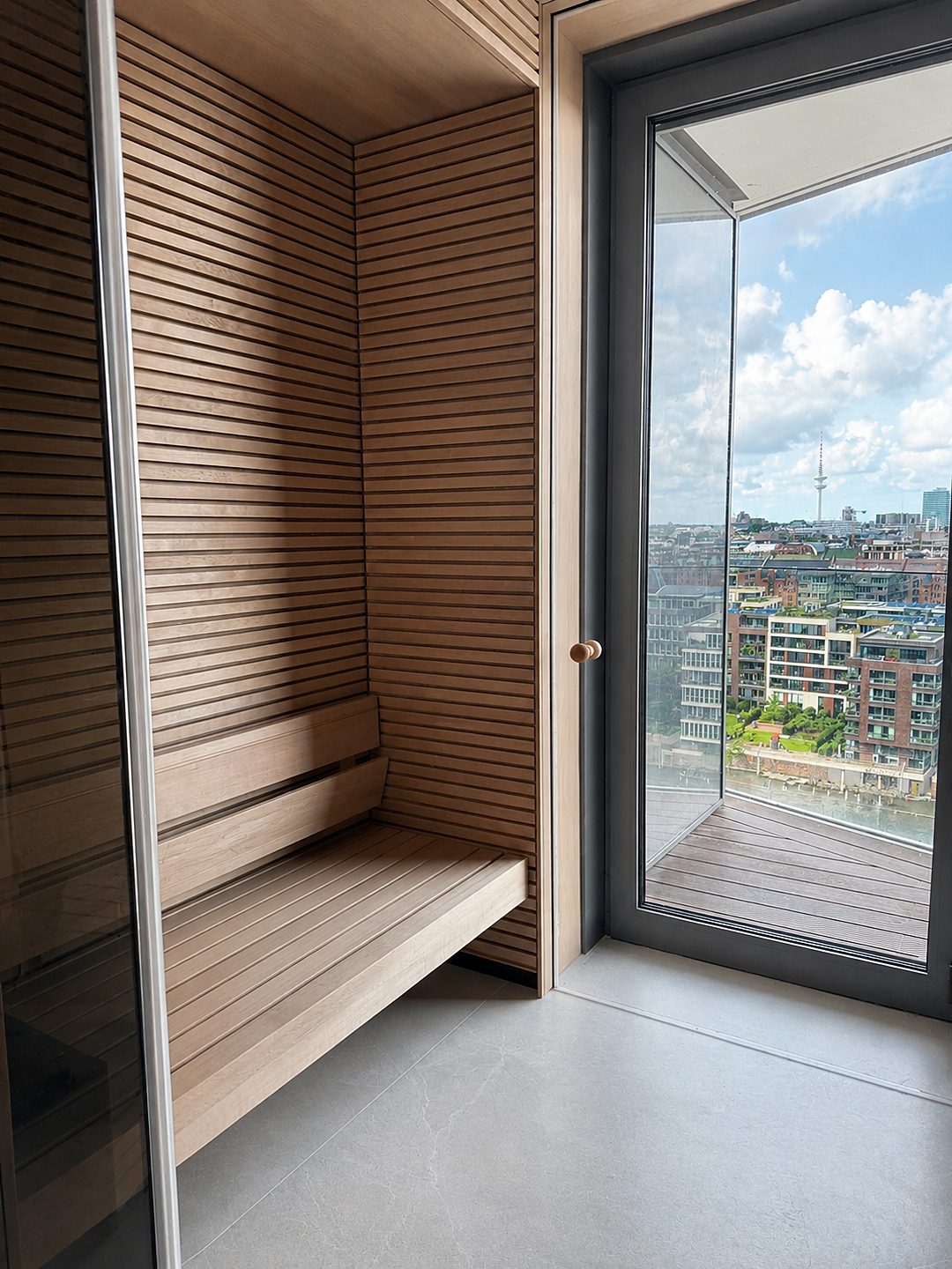 Sauna mit Holzverkleidung und Ausblick in der Musterwohnung