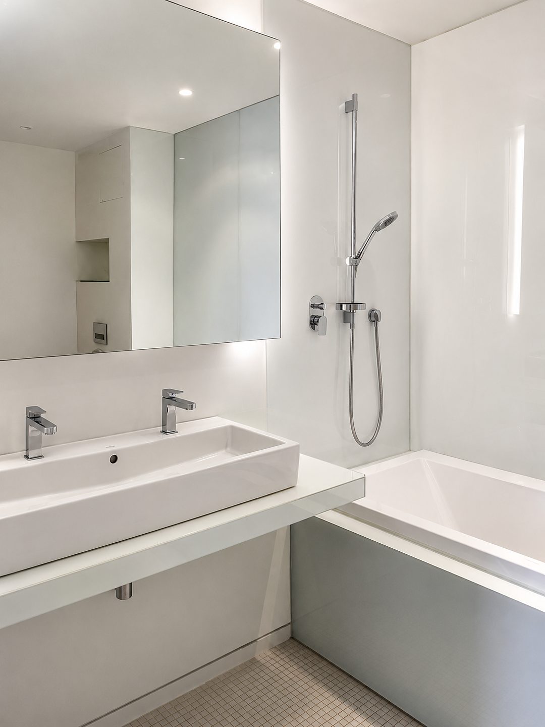 Gereinigtes Badezimmer mit Waschtisch, Badewanne und Spiegel